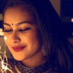 pexels-photo-802457-802457 Portrait of a smiling woman adorned with lights and elegant jewelry, creating a warm, glamorous atmosphere.